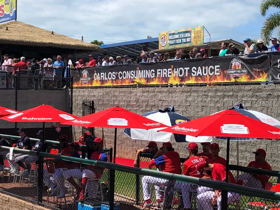 Carlos' Consuming Fire banner on the outfield wall at BayCare Ballpark