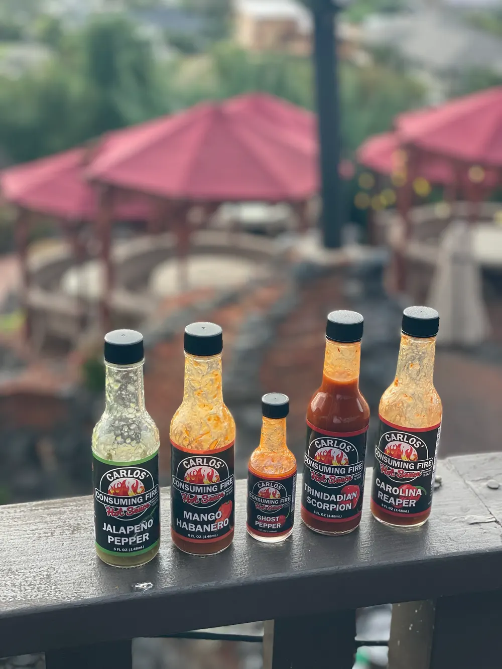 All five Carlos' Consuming Fire bottles lined up outdoors